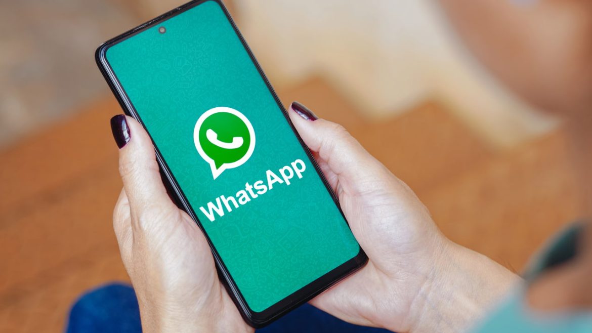 Um empreendedor sorri olhando para seu celular, onde uma conversa de venda no WhatsApp é concluída com sucesso, simbolizando o poder dos roteiros de IA para aumentar a conversão.
