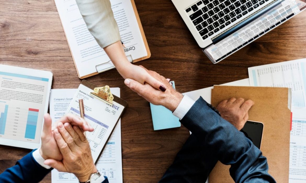 Uma pessoa conversa ao telefone com confiança, olhando para um roteiro em seu notebook que tem um ícone de IA e um cadeado, simbolizando a renegociação de dívidas com segurança.