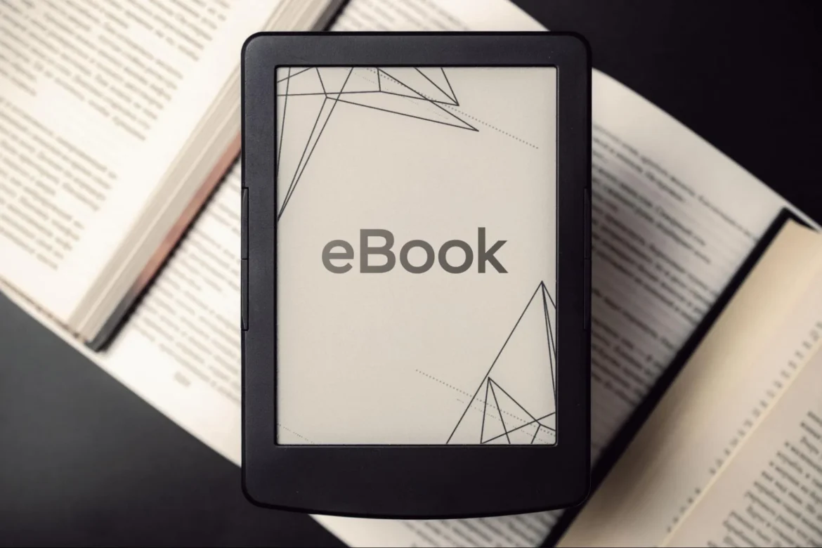 Uma pessoa sorrindo em frente a um laptop que mostra um e-book pronto e uma página de vendas, com um relógio ao fundo marcando 24 horas, simbolizando a criação e venda de um e-book com IA.