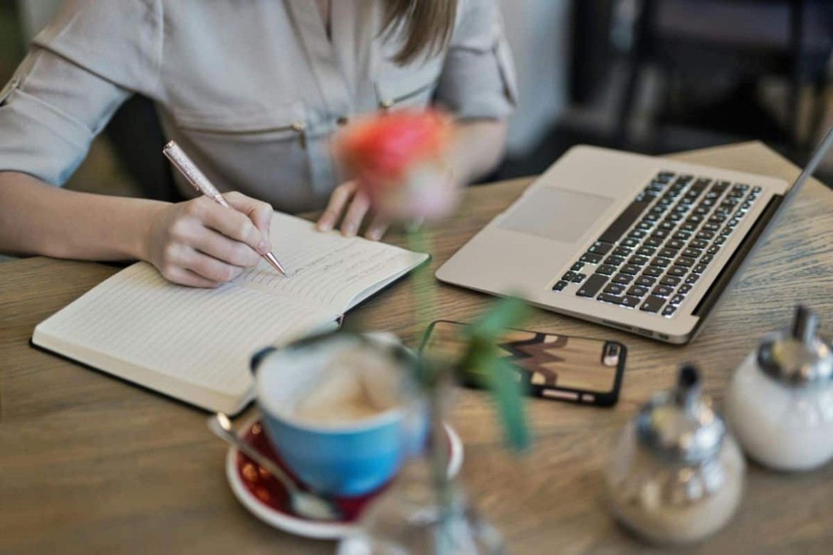 pessoa sorrindo em frente a um notebook que exibe um mapa mental com ideias de renda extra, ilustrando o uso de prompts para criar um plano personalizado.