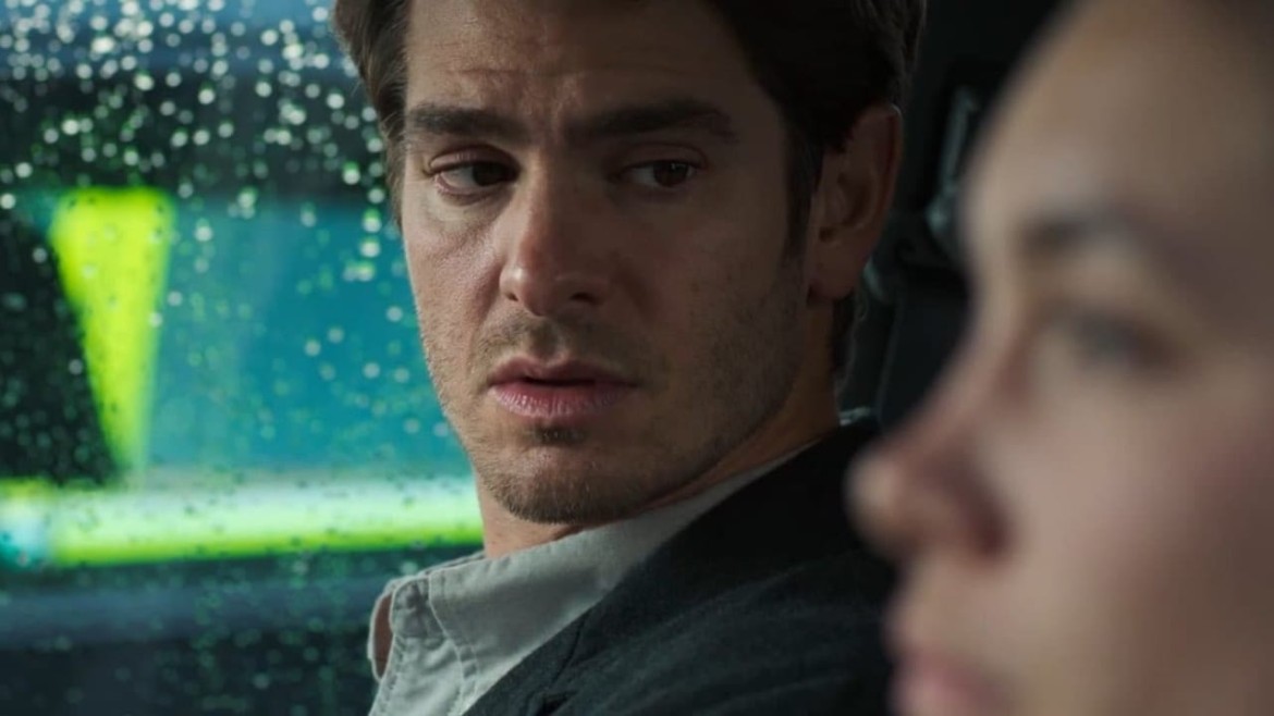 O ator Andrew Garfield, caracterizado como Sam Altman, em frente a uma casa moderna, simbolizando a locação real da biografia do CEO da OpenAI.