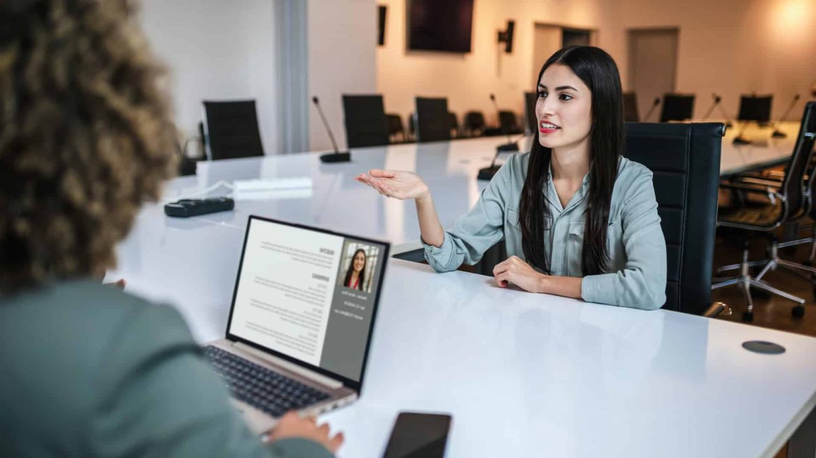 Profissional de RH em frente a uma tela de computador, analisando perfis de candidatos com o suporte de uma interface de IA, ilustrando o uso de prompts para recrutamento.